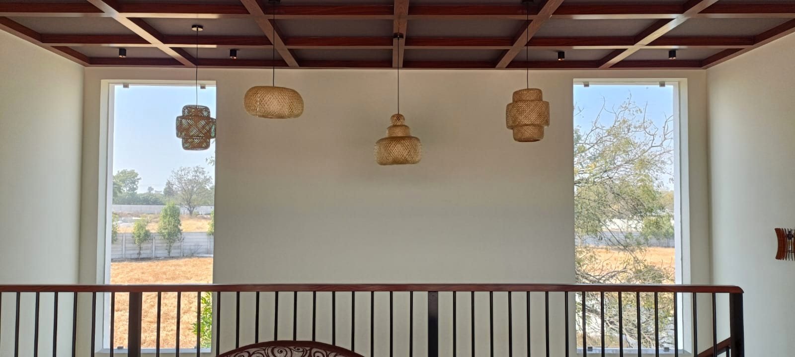 The upstairs landing with woven rattan pendant lights and windows on both sides.