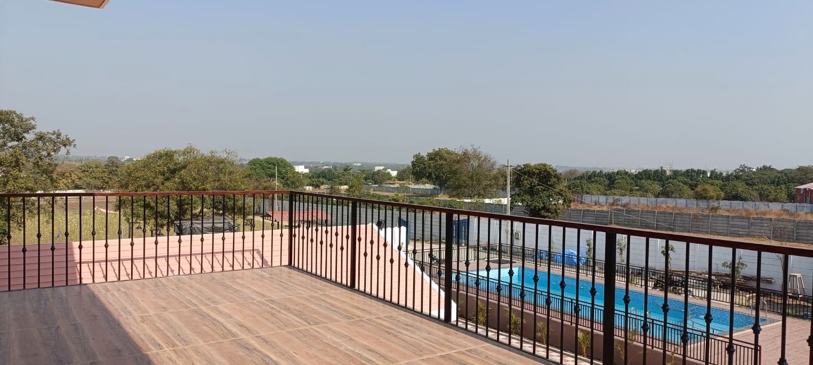 The wooden terrace deck looking out over the swimming pool and the open country beyond.